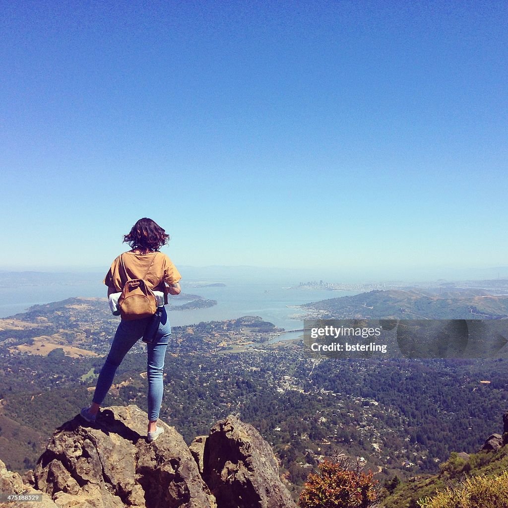 Woman standing on Mount Tamalpais looking at city, San Francisco, California, America, USA