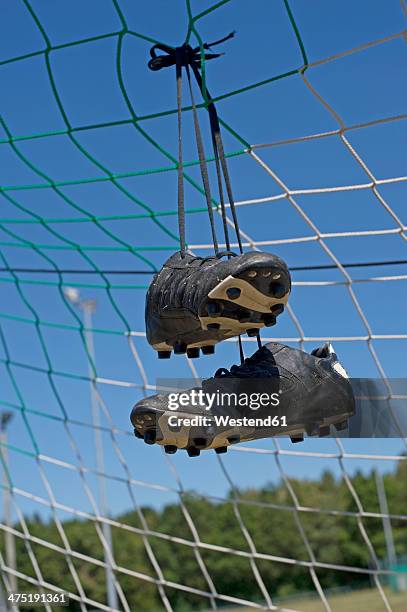 germany, bavaria, munich, football shoes hanging in football net - chuteira imagens e fotografias de stock