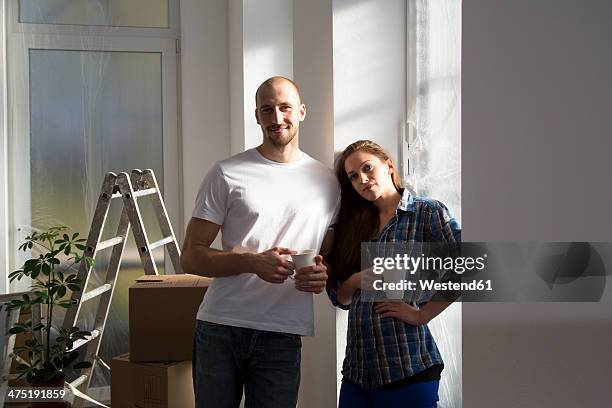 young couple moving into new home, taking a coffee break - young couple moving house stock pictures, royalty-free photos & images