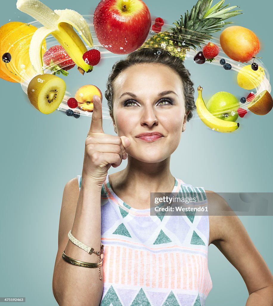 Young woman with flying fruits around her head, Composite