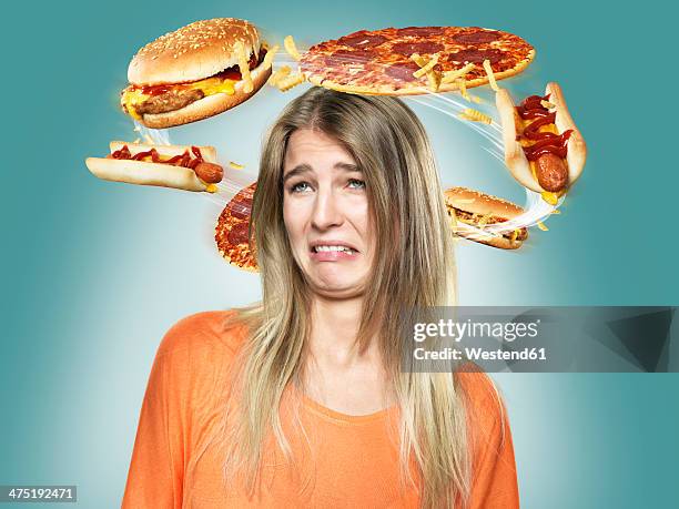 disgusted young woman with flying fast food around her head, composite - frau fleisch ekel stock-fotos und bilder