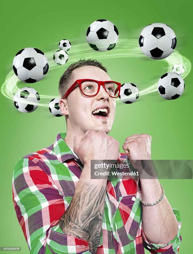 Young man with flying footballs around his head, Composite