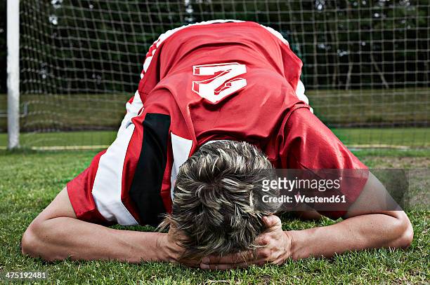 frustrated soccer player on field - athlete defeat stock pictures, royalty-free photos & images