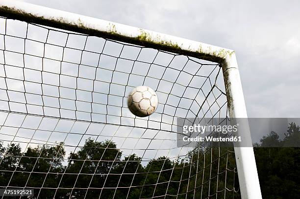 soccer ball in goal - scoring a goal stock-fotos und bilder
