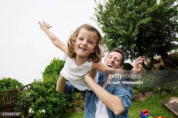 father playing with his little daughter in the garden - toddlers playing outdoor stock pictures, royalty-free photos & images