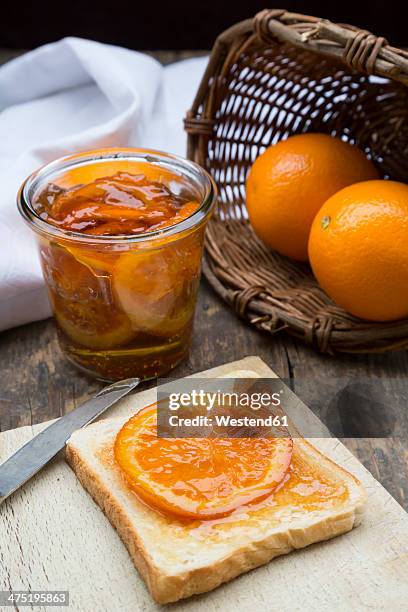 glass of orange marmalade with orange slices and toast - marmalade stock pictures, royalty-free photos & images