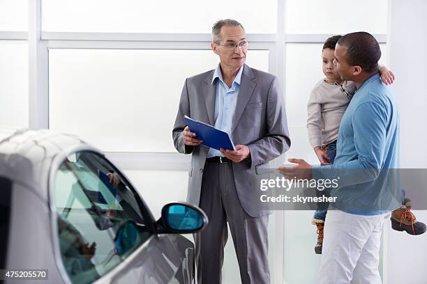 african american father and son discussing with a car salesperson. - conversation car bildbanksfoton och bilder