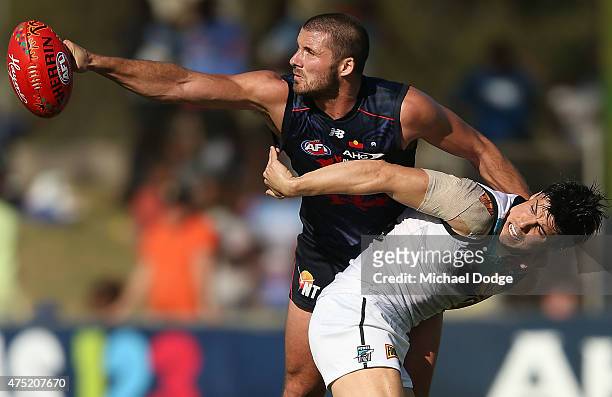 Colin Garland of the Demons punches the ball away from Angus Monfries during the round nine AFL match between the Melbourne Demons and the Port...
