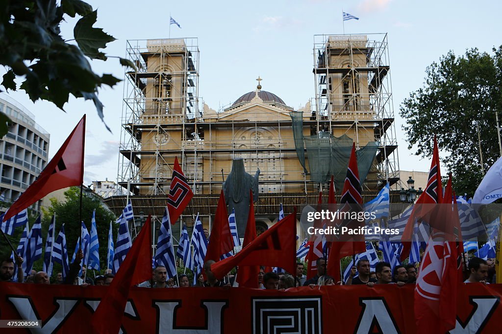 Golden Dawn sympathizers listen to the speeches, holding...