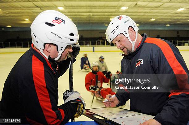 Paralympic Sled Hockey Team General Manager Dan Brennan, and Assistant Coach Guy Gosselin discuss the next drill during the team's practice at the...