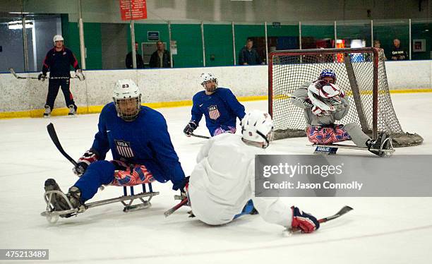 Paralympic Sled Hockey Team goalie Steve Cash blocks a shot during the team's practice at the Sertich Ice Arena on February 26, 2014 in Colorado...