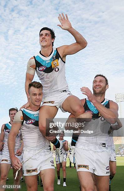 Angus Monfries of the Power is hoisted up by Robbie Gray and Jay Schulz after winning in his 200th game during the round nine AFL match between the...