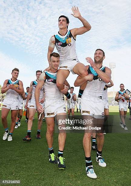 Angus Monfries of the Power is hoisted up by Robbie Gray and Jay Schulz after winning in his 200th game during the round nine AFL match between the...