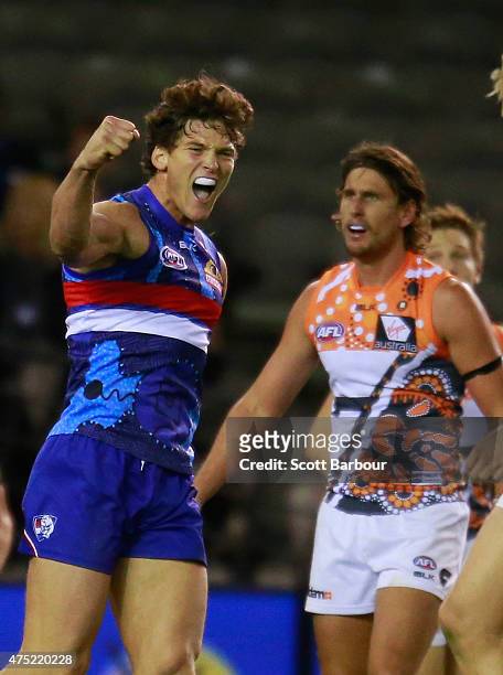 Will Minson of the Bulldogs celebrates after kicking a goal as Ryan Griffen of the Giants looks on during the round nine AFL match between the...