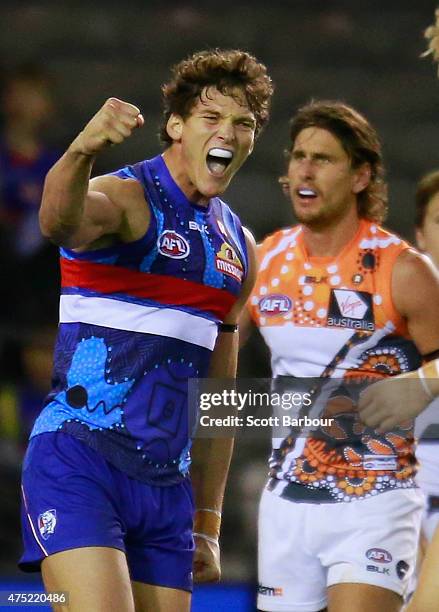 Will Minson of the Bulldogs celebrates after kicking a goal as Ryan Griffen of the Giants looks on during the round nine AFL match between the...