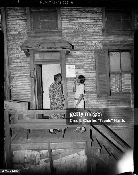 Hattie Dodson and daughter Mary Davenport, standing on steps of their house with sign from Health Department to Vacate Premises, 2325 Mahon Street...