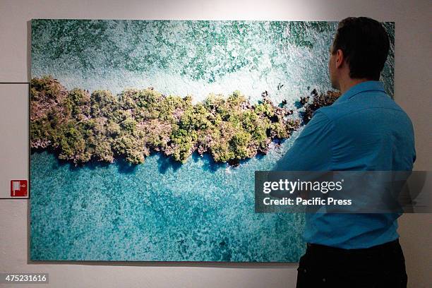 Man observes the paintings in the wall. "Sulla rotta delle spezie" is the exhibition, with 73 photographs, which houses the MAO, in collaboration...