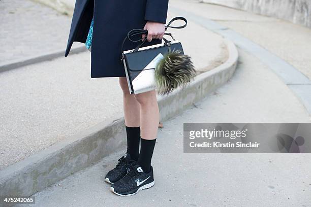 Model Ming Xi wears a Celine coat, Proenza Schouler skirt, Fendi bag, Nike trainers and Jil Sander top on day 2 of Paris Collections: Women on...