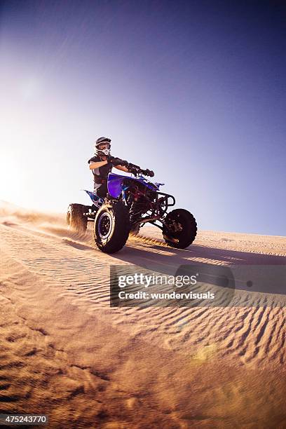 all-terrain vehicle travelling over a sand dunes - atv sand dune stock pictures, royalty-free photos & images