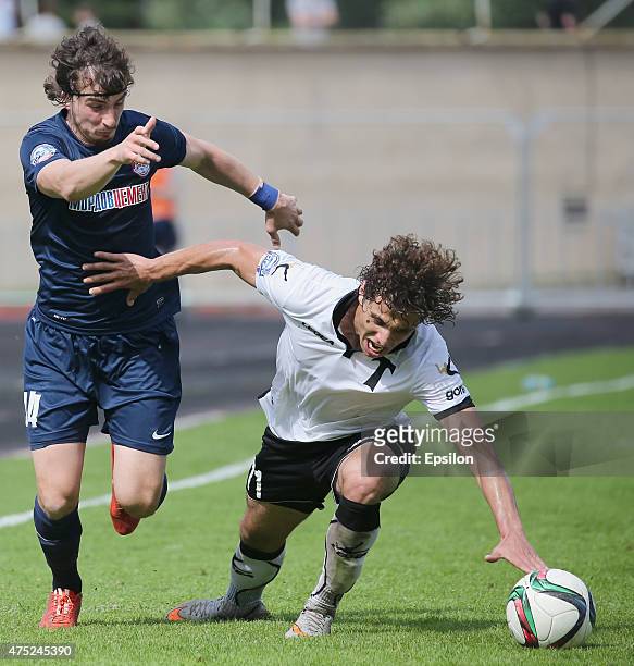 Georgy Tigiev of FC Torpedo Moscow is challenged by Pavel Yakovlev of FC Mordovia Saransk during the Russian Premier League match between FC Torpedo...