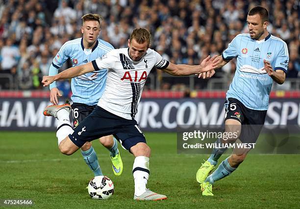 Tottenham Hotspur player Harry Kane shoots as Sydney FC defenders Alexander Gersbach and Matthew Jurman look on in their friendly football match in...