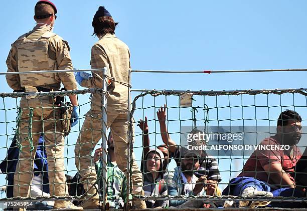 Belgian sailors distribute water to migrants aboard the Godetia logistical support ship of the Belgian Navy on May 30, 2015 upon its arrival in the...