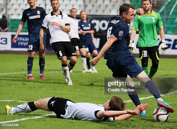 Semyon Fomin of FC Torpedo Moscow is challenged by Anton Bober of FC Mordovia Saransk during the Russian Premier League match between FC Torpedo...