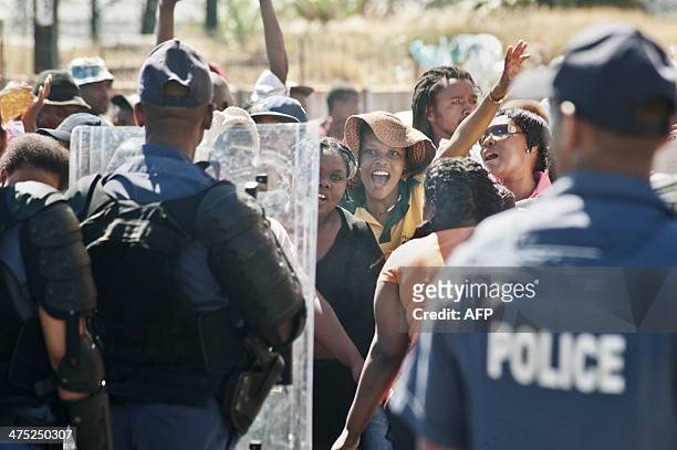 South African policemen block a road to prevent about 1000 people taking part in a protest against poor sanitation, from marching into Cqpe Town...