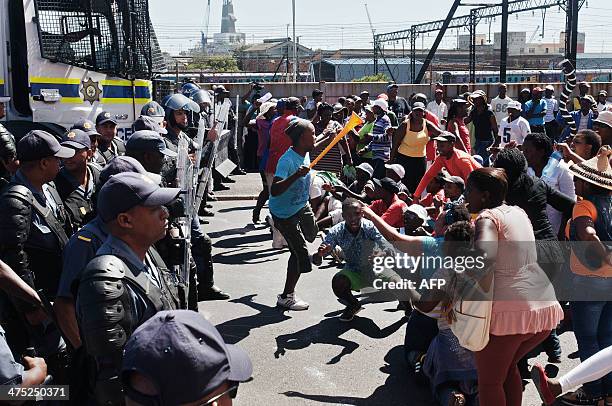 South African policemen block a road to prevent about 1000 people taking part in a protest against poor sanitation, from marching into Cape Town...