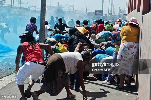 People taking part in a protest against poor sanitation run away from a water cannon and stun grenades fired by members of the South African Police...