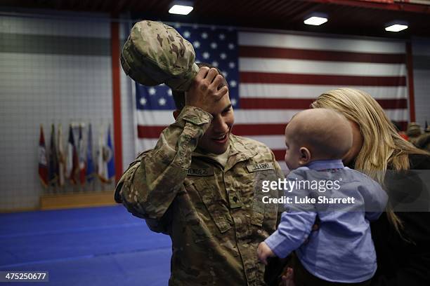 Spc. Andrew Mendez of the U.S. Army's 3rd Brigade Combat Team, 1st Infantry Division, reacts upon seeing his five month-old son Elliot Mendez...