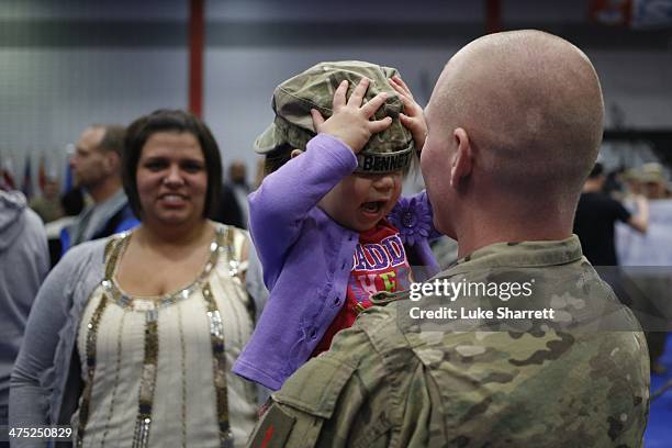 Spc. Brian Bennett of the U.S. Army's 3rd Brigade Combat Team, 1st Infantry Division, holds his 2-year-old daughter Sophia following a homecoming...