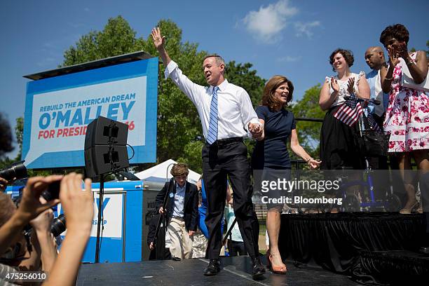 Martin O'Malley, former governor of Maryland, left, waves as he arrives with his wife Katie O'Malley to announce he will seek the Democratic...