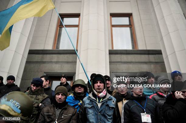 Maidan self-defence activists stand guard as people rally outside the Ukrainian parliament building in Kiev on February 27, 2014. Ukraine's...