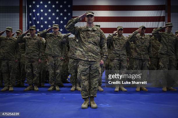 Soldiers from the U.S. Army's 3rd Brigade Combat Team, 1st Infantry Division, salute during the playing of the Star Spangled Banner during a...