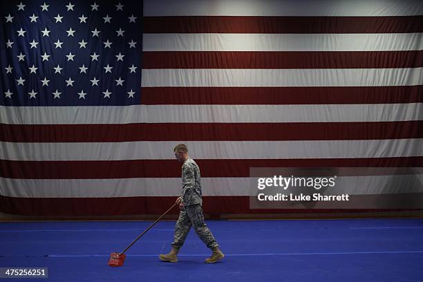 Army Spc. Nathan Bookout sweeps the floor following a welcome home ceremony for members of the U.S. Army's 3rd Brigade Combat Team, 1st Infantry...