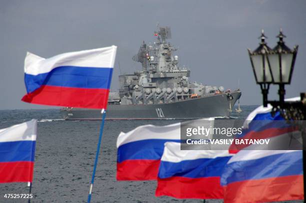 Pro-Russian supporters wave flags as they welcome missile cruiser Moskva, a flagship of Russian Black Sea Fleet, entering Sevastopol bay on September...