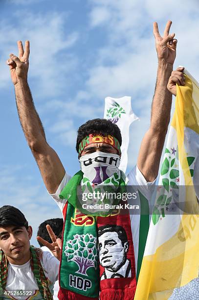 Supporter flashes V sign of Turkey's pro-Kurdish People's Democtratic Party leader Selahattin Demirtas as he addresses a rally ahead of the June 7...