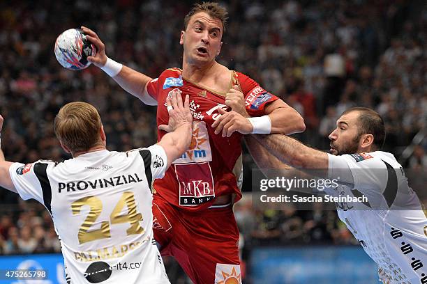 Momir Ilic of Veszprem is challenged by Aron Palmarsson and Joan Canellas Reicach of Kiel during the "VELUX EHF FINAL4" semi final match between THW...