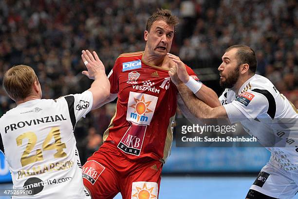 Momir Ilic of Veszprem is challenged by Aron Palmarsson and Joan Canellas Reicach of Kiel during the "VELUX EHF FINAL4" semi final match between THW...