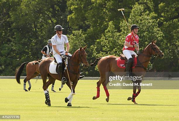 Prince Harry and Jack Mann play during day one of the Audi Polo Challenge at Coworth Park on May 30, 2015 in London, England.