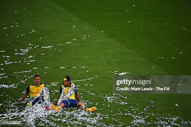 Olivier Giroud of Arsenal and his team-mate Francis Coquelin celebrate on the pitch after winning the FA Cup Final between Aston Villa and Arsenal at...