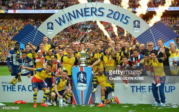 The Arsenal team pose with the trophy after winning the FA Cup final football match between Aston Villa and Arsenal at Wembley stadium in London on...