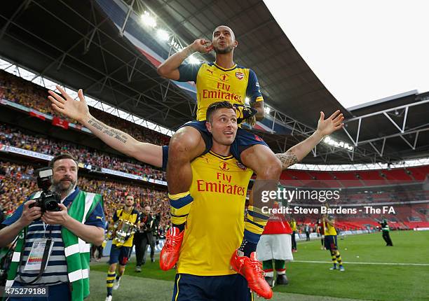 Theo Walcott of Arsenal celebrates on the shoulders of team-mate Olivier Giroud after winning the FA Cup Final between Aston Villa and Arsenal at...