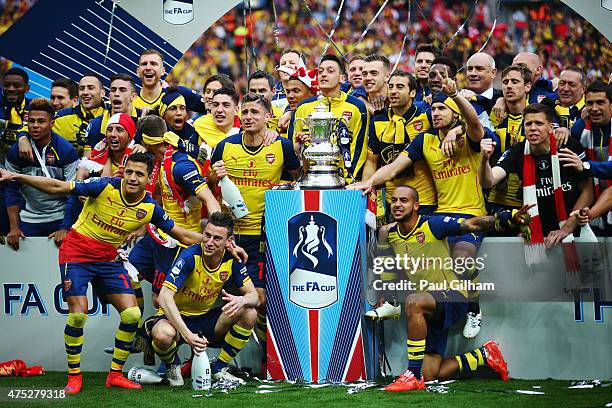 Arsenal players celebrate with the trophy after the FA Cup Final between Aston Villa and Arsenal at Wembley Stadium on May 30, 2015 in London,...