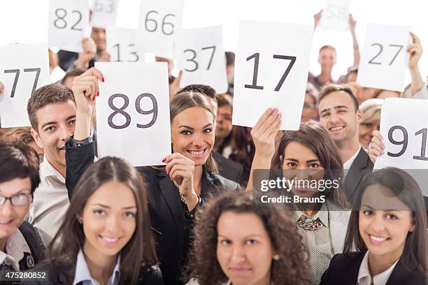 grand groupe de gens d'affaires heureux holding vente aux enchères des chiffres. - plaquette de vente aux enchères photos et images de collection