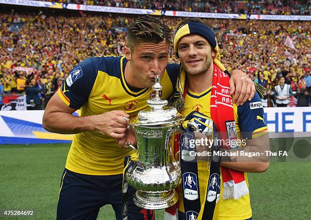 Olivier Giroud and Jack Wilshere of Arsenal celebrate on the pitch with the trophy after winning the FA Cup Final between Aston Villa and Arsenal at...