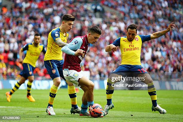 Jack Grealish of Aston Villa is watched by Hector Bellerin and Santi Cazorla of Arsenal during the FA Cup Final between Aston Villa and Arsenal at...