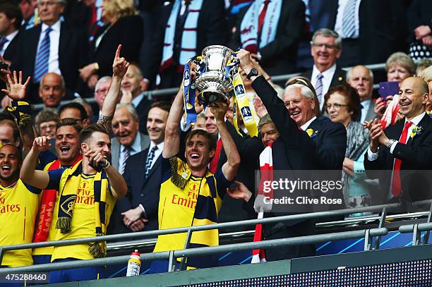 Nacho Monreal of Arsenal and Arsene Wenger manager of Arsenal lift the winners trophy following the FA Cup Final between Aston Villa and Arsenal at...