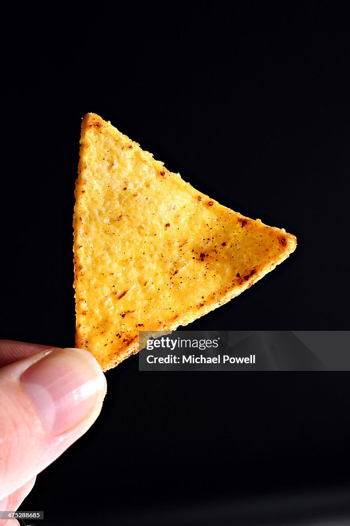 Individual tortilla chip being held